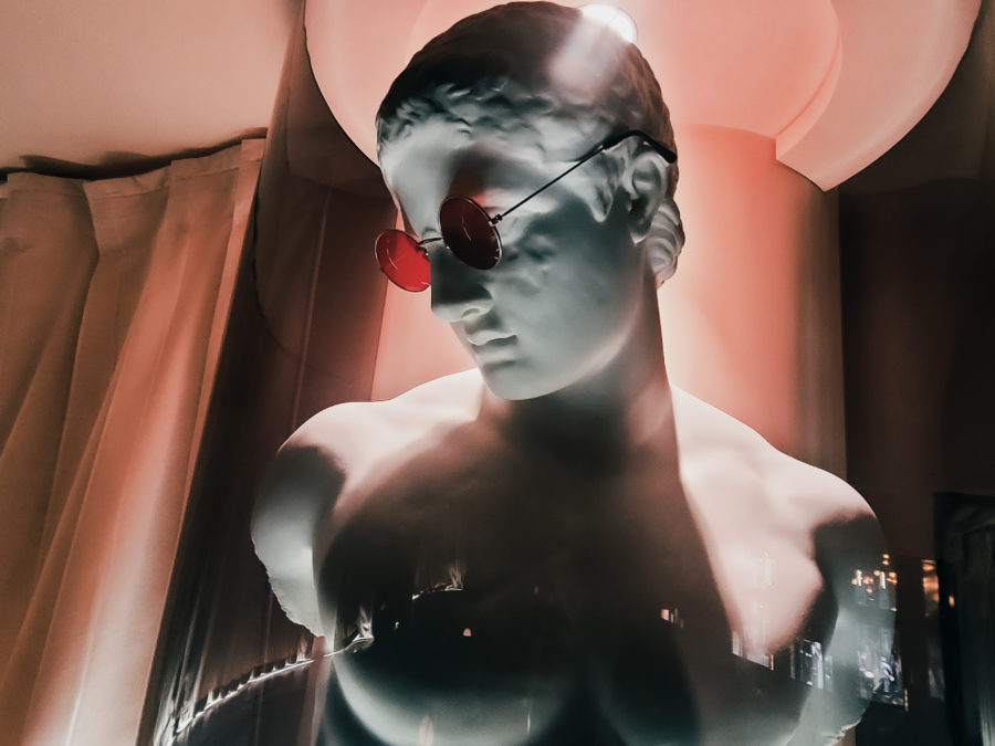 Buste statue grecque modernisé de manière esthétique, lumière rose, lunettes de soleil rose